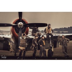À Duxford, un groupe en tenues d’aviation pose autour d’un Republic P-47 Thunderbolt au sol.
